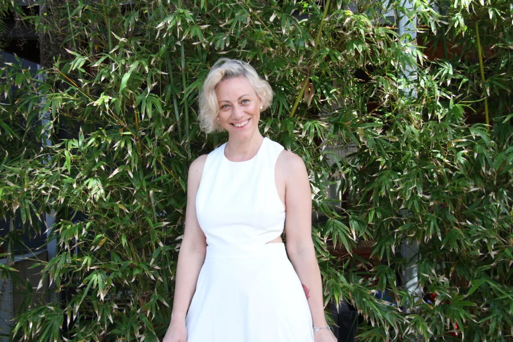 Kiah Bouchet in a white dress smiling in front of bamboo — Declutter With Kiah Perth