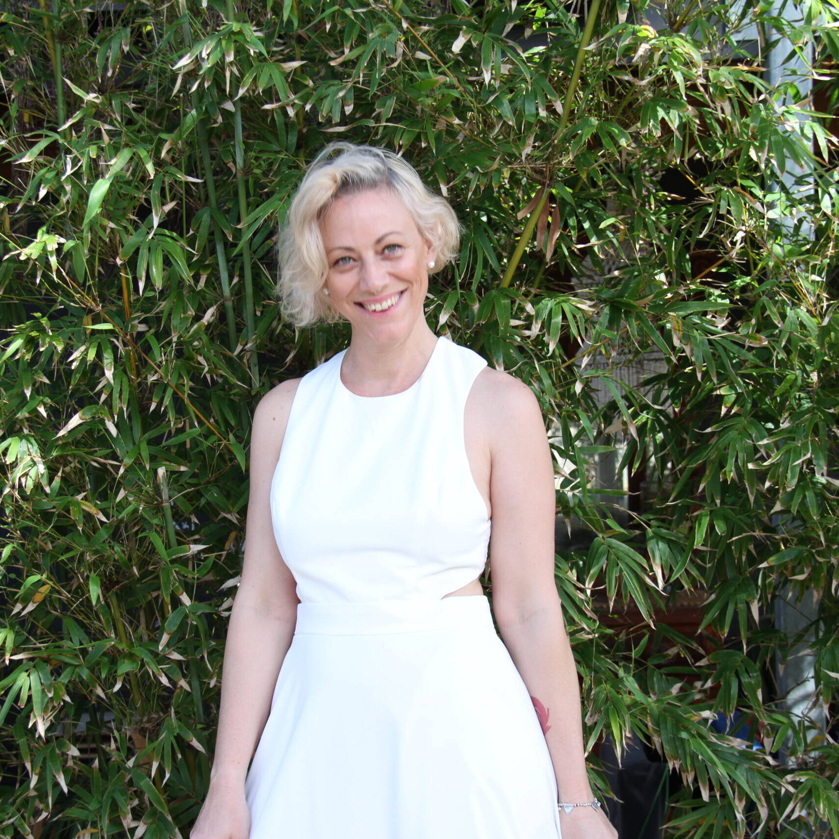 Kiah Bouchet in a white dress smiling in front of bamboo &mdash; Declutter With Kiah Perth